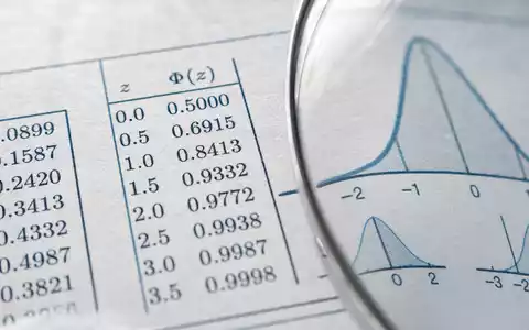 Verisk Analytics (US92345Y1064) rückt in Makroaufnahme gedruckte Statistiktabellen und Verteilungskurven unter einer Lupe ins Bild - Foto: THN