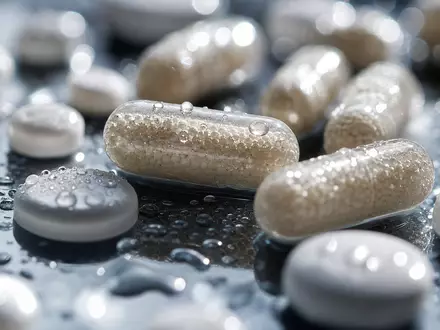 Vertex Pharma US92532F1003 zeigt eine Makroaufnahme von Pharma-Kapseln und Tabletten mit feinen Wassertropfen - Foto: THN
