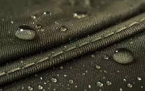 Makroaufnahme zeigt wasserabweisendes technisches Gewebe mit Tropfen, VF Corporation ISIN US9255241033 illustriert Materialinnovation der Textilproduktion - Foto: THN