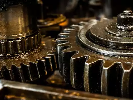 Deere & Co. Makro-Detailaufnahme geölter Stahlzahnräder aus dem industriellen Maschinenbau-Sektor, ISIN US24419L1061 - Foto: THN