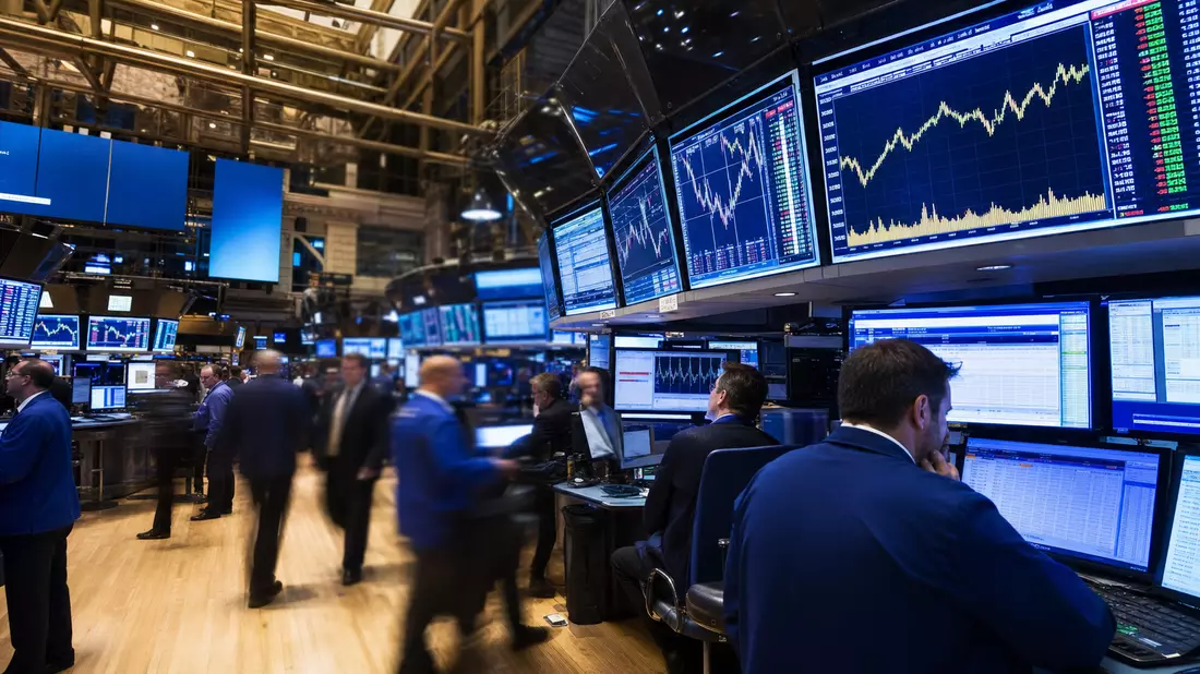 NYSE Trading-Floor mit Händlern an Bildschirmen und Kurs-Charts für Industrieaktien