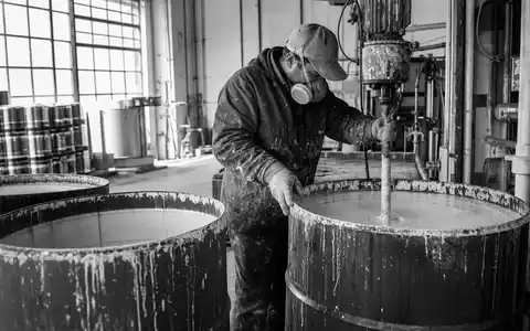 Schwarzweiße Reportage-Aufnahme dokumentiert Produktionsalltag der Chemiefirma Akzo Nobel N.V., ISIN NL0013267909, in Farbenfabrik - Foto: THN