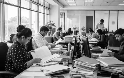 NN Group N.V. (ISIN NL0010773842) zeigt dokumentarisch Mitarbeitende bei Prüfung von Versicherungsunterlagen im Büro - Foto: THN