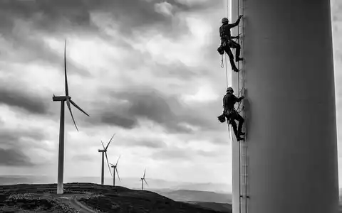 Energiekontor AG DE0005313506 zeigt Techniker in Schwarz-Weiß beim Klettern an einer Windkraftanlage - Foto: THN