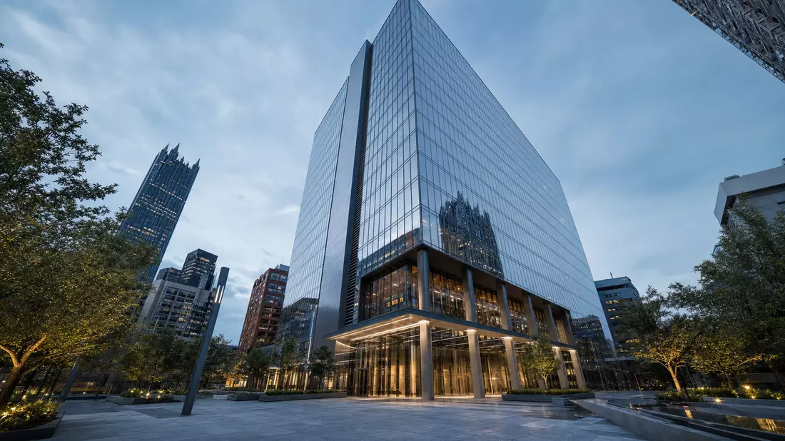 CGI-Render eines modernen Glas-Stahl-Hochhauses in Pittsburgh mit beleuchteter Lobby