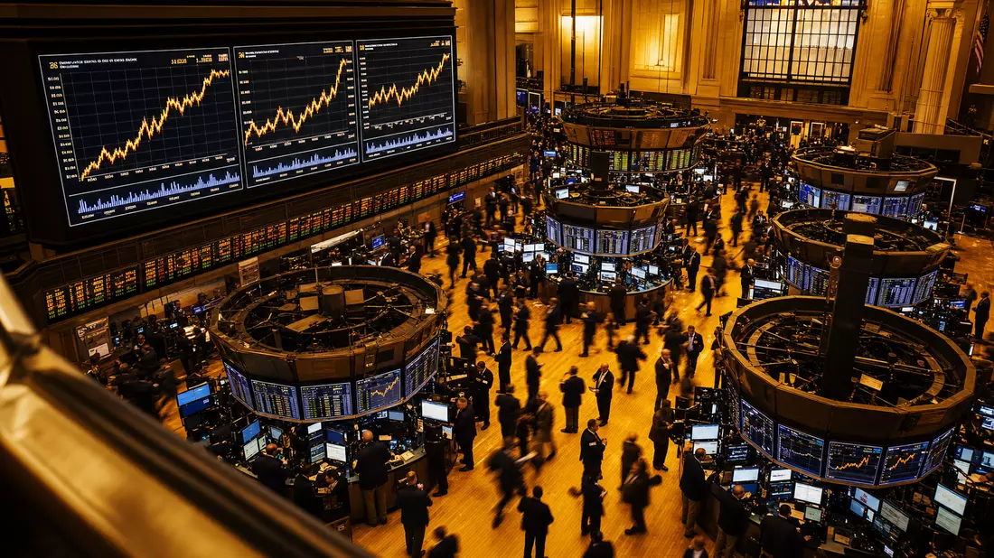 Redaktionsfoto des NYSE-Börsensaals mit Energiesektor-Charts auf großen Bildschirmen und Tradern