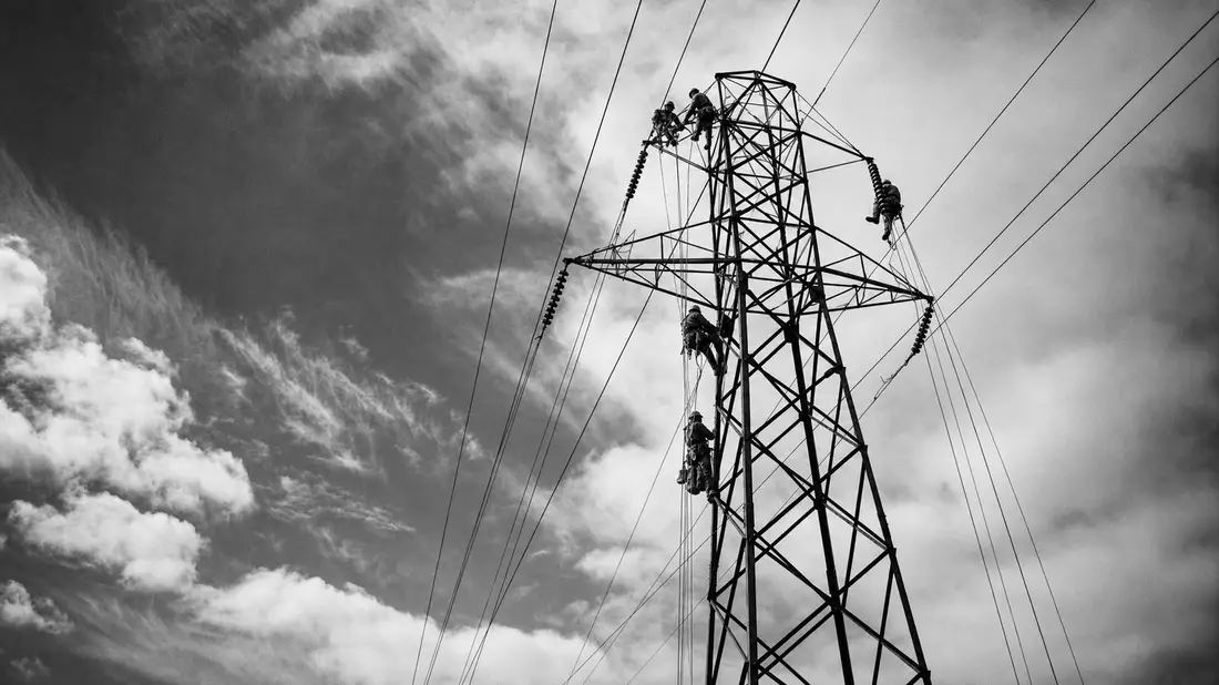 Schwarzweiß-Reportage: Elektriker auf Hochspannungsturm von Entergy Corp