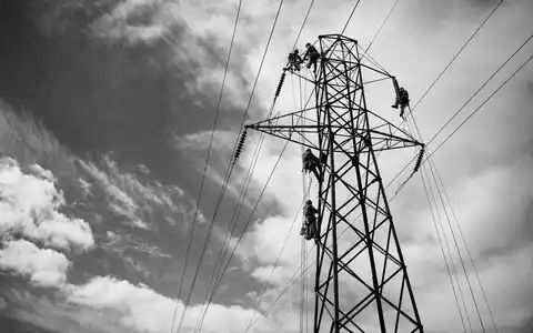 Entergy Corp. zeigt Elektriker beim Erklimmen eines Hochspannungsturms in einer dokumentarischen Schwarzweißaufnahme, ISIN US29364G1031 - Foto: THN