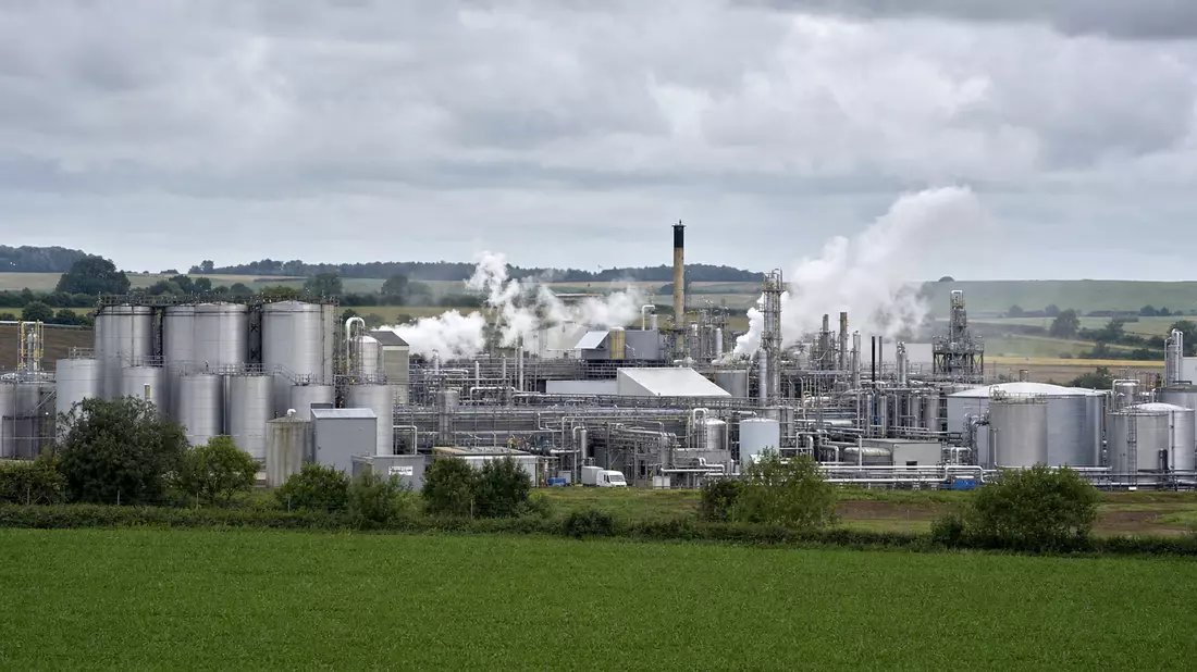 Chemieanlage mit Silotanks und Dampf in grüner Landschaft bei Snaith, England