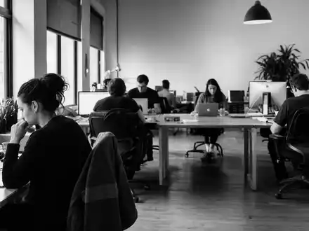 The Sage Group plc (GB00B8C37574) in dokumentarischer Schwarzweiß-Reportage mit Angestellten in einem Softwareunternehmen-Großraumbüro - Foto: THN