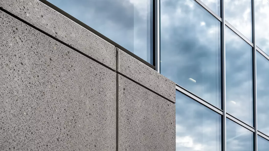 Nahaufnahme Betonpanel trifft Glasvorhangwand an modernem Bürogebäude