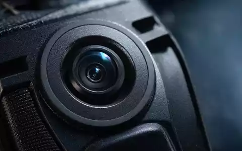 Axon Enterprise Inc. zeigt Makro-Detailaufnahme einer ungebrandeten Bodycam-Linse in extremer Nahaufnahme, US05464C1018 - Foto: THN