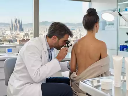 Almirall S.A. (ES0157097017) zeigt Dermatologie-Praxis mit Hautuntersuchung und unbeschrifteten Cremetuben in Barcelona - Foto: THN