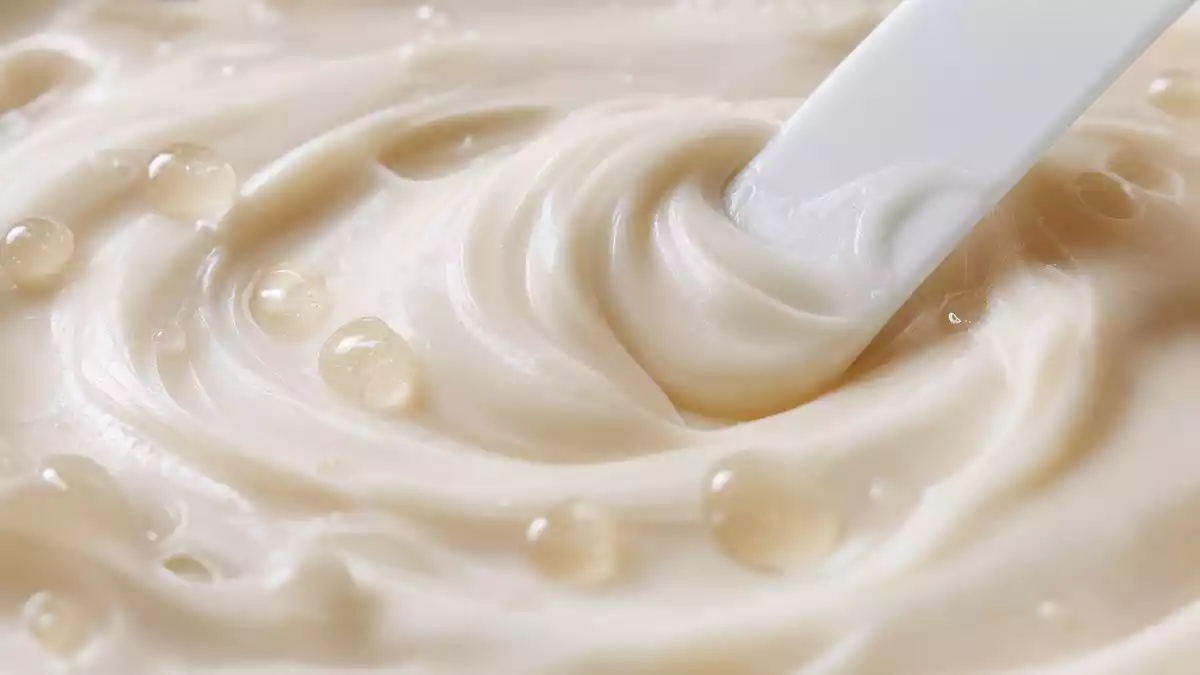 Extreme Nahaufnahme einer verwirbelten Hautcreme mit glänzenden Tröpfchen