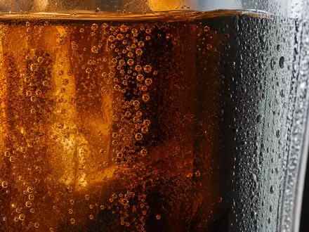 Makroaufnahme zeigt Kohlensäure-Bläschen in unmarkiertem Glas, symbolisch für The Coca-Cola Company US1912161007 und ihre Getränke - Foto: THN