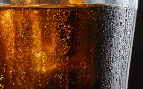 Makroaufnahme zeigt Kohlensäure-Bläschen in unmarkiertem Glas, symbolisch für The Coca-Cola Company US1912161007 und ihre Getränke - Foto: THN