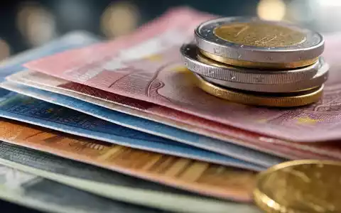 Commerzbank AG DE000CBK1001 zeigt Makroaufnahme von Euro-Banknoten und Münzen mit feiner Papierstruktur und weichem Bokeh-Hintergrund - Foto: THN