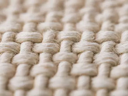 Dunelm Group plc GB0033745292 zeigt in Makroaufnahme die feine Webstruktur eines gewebten Baumwollstoffes - Foto: THN