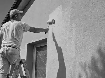 Sherwin-Williams (US8243481051) steht für die Beschichtungsbranche, dokumentiert durch einen Maler beim sorgfältigen Wandanstrich am Haus - Foto: THN