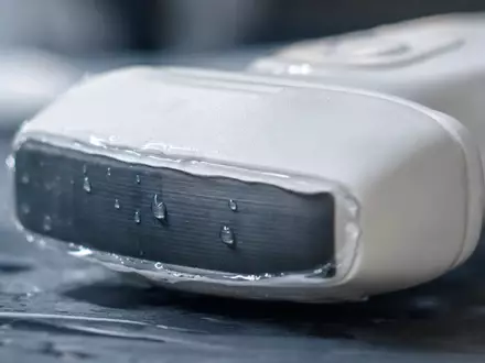 Siemens Healthineers DE000SHL1006 fokussiert Makroaufnahme einer unmarkierten Ultraschallsonde mit glänzenden Geltropfen im Detail - Foto: THN