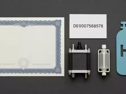 SFC Energy AG DE0007568578 zeigt ein Flatlay mit Aktienzertifikat, ISIN-Karte, Brennstoffzelle und Wasserstoffzylinder-Symbol - Foto: THN