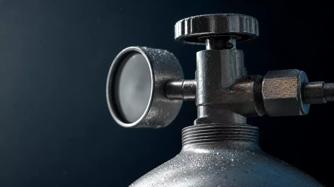Makroaufnahme eines Wasserstoffzylinder-Ventils mit Metalltextur und Wassertropfen