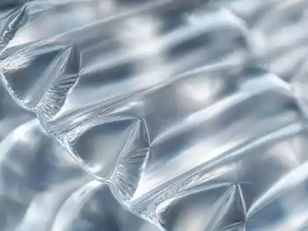 Sealed Air Corp. (US81211K1007): Makroaufnahme von transparenter Luftpolsterfolie mit Licht, das durch die Luftkammern bricht - Foto: THN