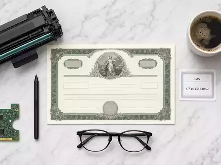 HP Inc. Aktienzertifikat und ISIN-Karte US40434L1052 im Flatlay mit Elektronik-Utensilien auf Marmor - Foto: THN