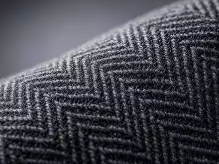 Hugo Boss AG DE000A1PHFF7 – Makroaufnahme zeigt feines Fischgrät-Wollgewebe aus der Premiummode Textilproduktion - Foto: THN