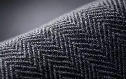 Hugo Boss AG DE000A1PHFF7 – Makroaufnahme zeigt feines Fischgrät-Wollgewebe aus der Premiummode Textilproduktion - Foto: THN