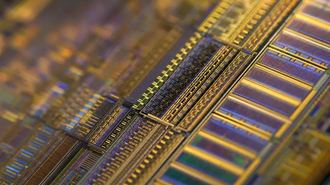 Makroaufnahme goldener Leiterbahnen und Transistorstrukturen auf einem Mikrochip