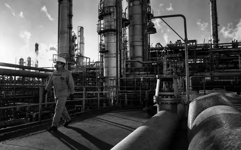 Symrise AG (DE000SYM9999) SW-Reportage dokumentiert Arbeiter auf Plattform einer Chemieanlage mit Destillationstürmen - Foto: THN