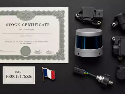Valeo SE FR0013176526 zeigt Flatlay mit Aktienzertifikat, ISIN-Karte, Lidar-Sensor und Automobilelektronik-Bauteilen auf dunklem Tisch - Foto: THN