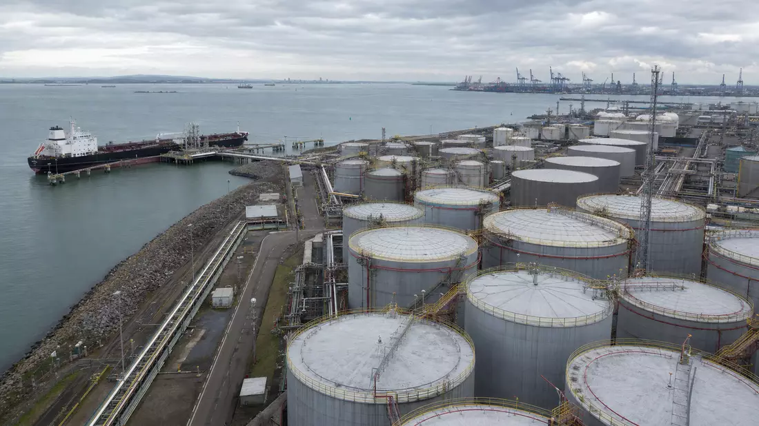 Industrielles Tanklager-Terminal am Hafen mit Tankschiff und Speichertanks
