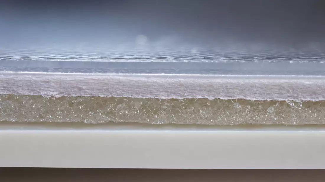 Makro-Querschnitt haftklebender Etikettenfolie mit sichtbarer Klebstoffschicht