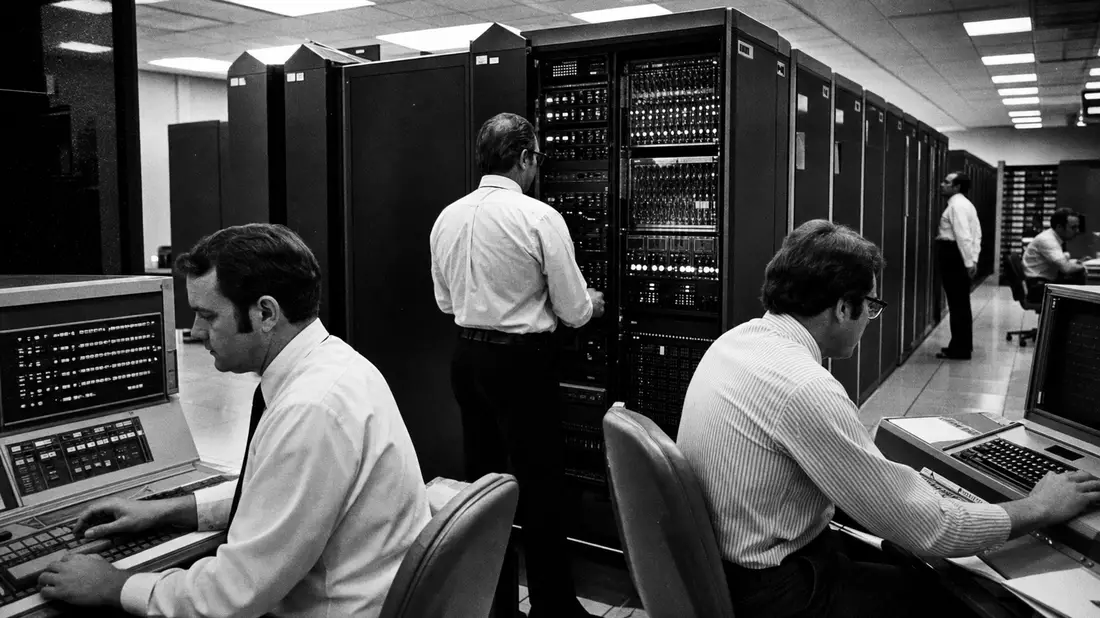 Schwarzweiß-Reportage eines Rechenzentrums mit Technikern an Mainframes