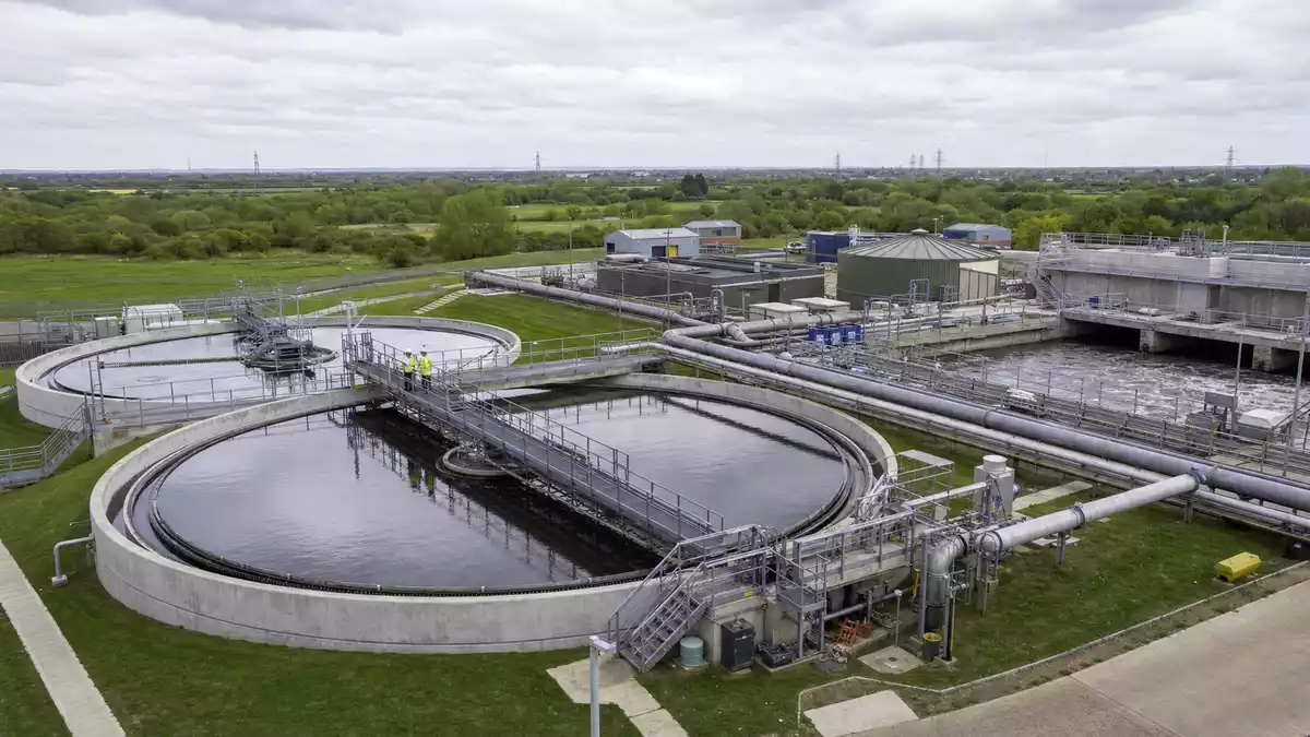 Fotorealistische Klaranlage mit runden Becken bei bewoelktem Himmel in England