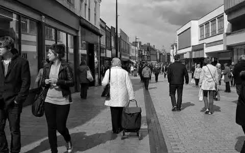 Schwarzweiß-Reportage einer Einkaufsstraße symbolisiert Marks and Spencer Group plc, ISIN GB0031215220, im Alltag - Foto: THN