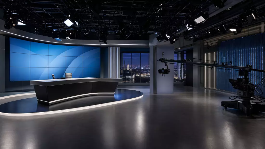 Modernes TV-Studio mit Videowand und Kamerakran, Nachtskyline im Hintergrund