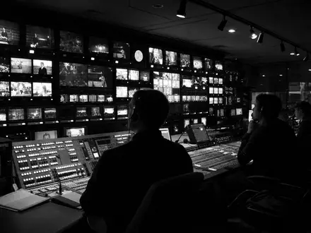 RTL Group LU0061462528 dokumentiert schwarzweiß einen Regieraum mit Monitorwand und konzentrierten Sendetechnikern bei Nacht - Foto: THN