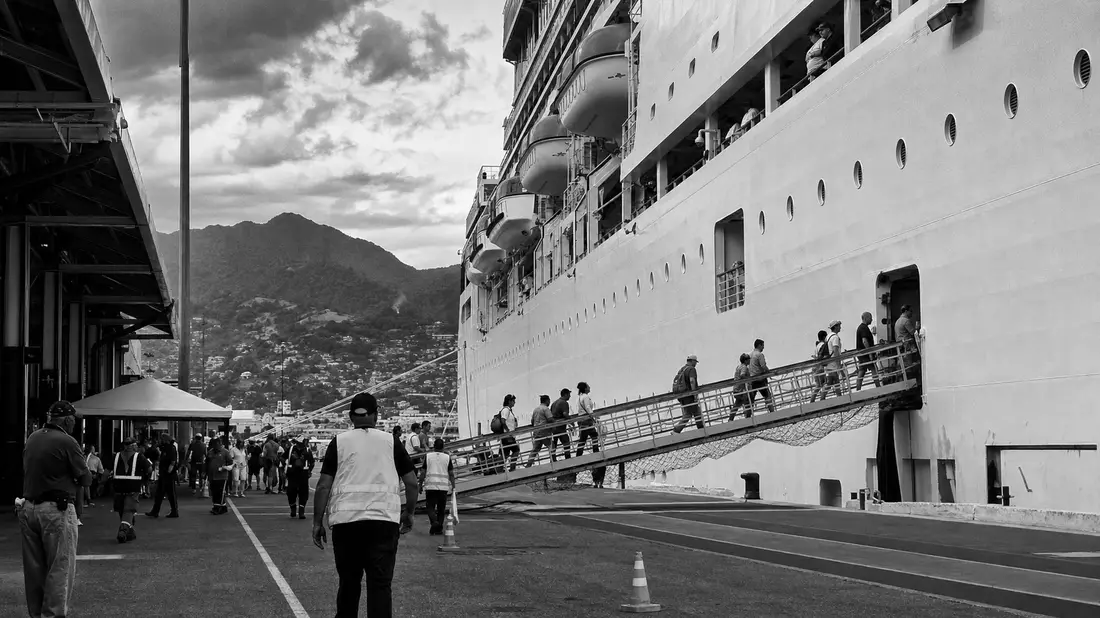 Dokumentarische Schwarzweißaufnahme von Passagieren beim Einstieg ins Kreuzfahrtschiff