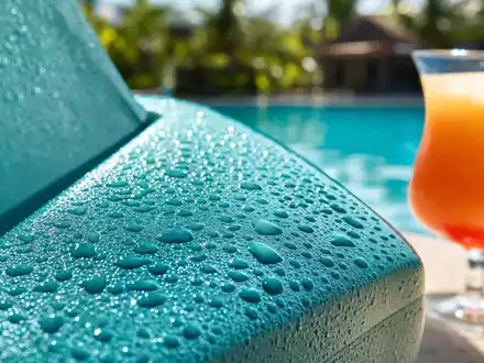 Makroaufnahme von Pool-Deck-Details der Royal Caribbean Group, ISIN LR0008862868, Wassertropfen und Cocktailglas - Foto: THN