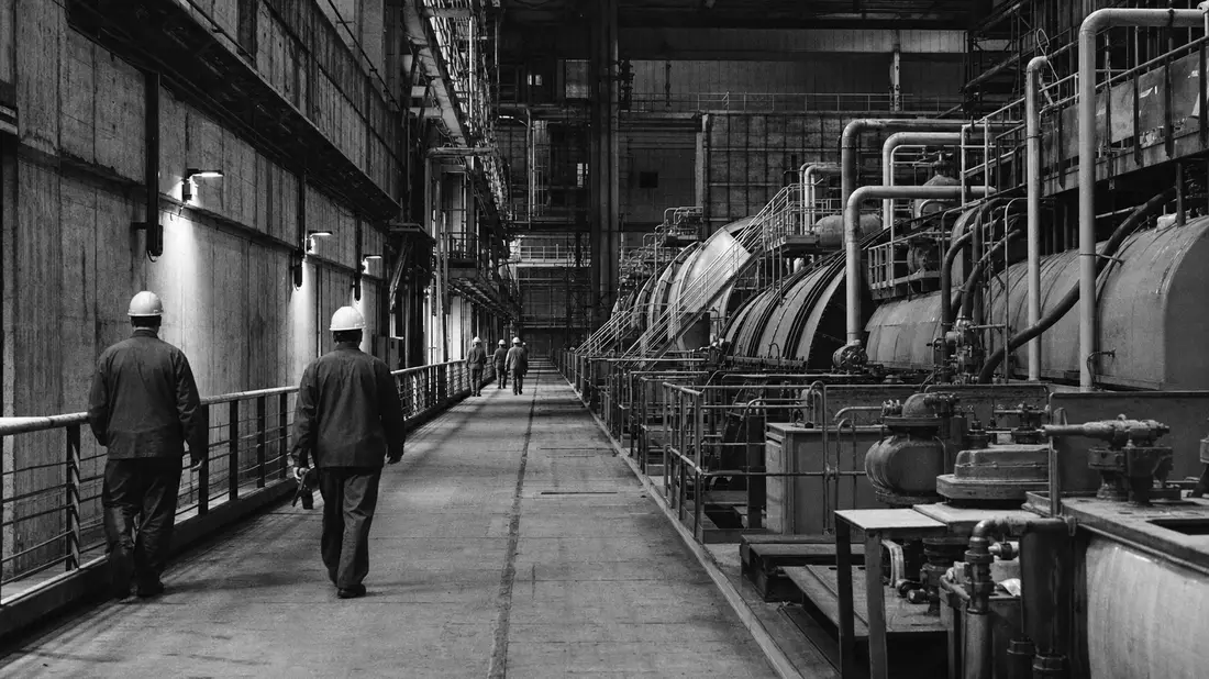 Schwarzweißfoto von Arbeitern in einer nuklearen Turbinenhalle