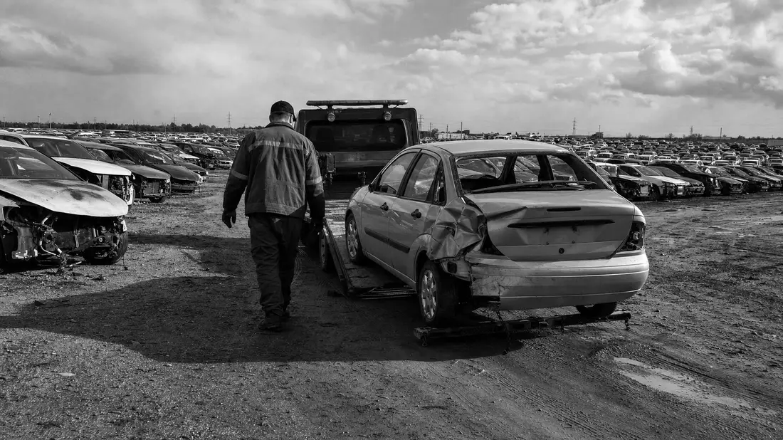 Schwarz-Weiß-Reportagefoto eines Copart-Auktionshofs mit Abschleppwagen