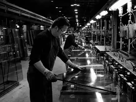 Corning Inc. Glasfertigung US2193501051 – Schwarzweißreportage von Arbeitern an langer Produktionslinie in Industriehalle - Foto: THN