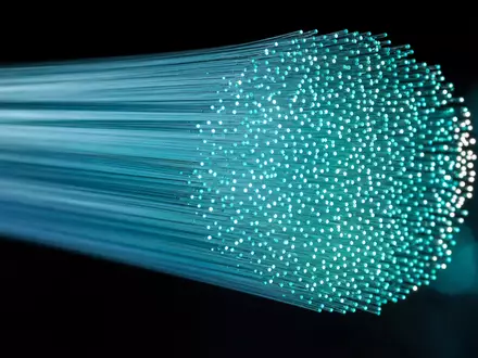 Corning Inc. Optikfaser-Makro US2193501051 – Leuchtende Glasfasern mit türkisem Lichtbündel auf dunklem Hintergrund - Foto: THN