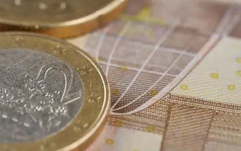 Makroaufnahme von Münzen und Banknotenstruktur, passend zum Finanzunternehmen KBC Group NV, ISIN BE0003565737 - Foto: THN