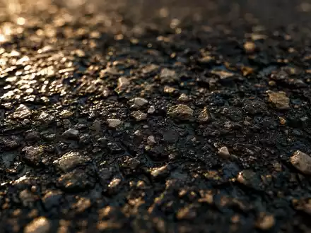 Detaillierte Makroaufnahme von nassem Asphalt zeigt Baumaterial-Textur und steht für Ferrovial SE, ISIN NL0015001IX2, Baukonzern - Foto: THN