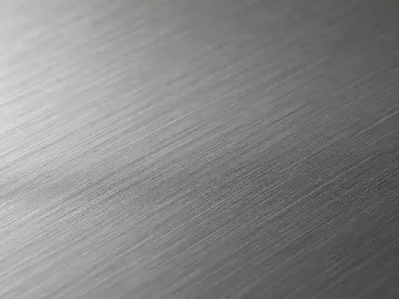 ArcelorMittal S.A. (LU1598757687) stellt Stahlprodukte her, diese Makroaufnahme zeigt die feine Textur einer gebürsteten Metalloberfläche - Foto: THN
