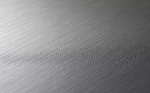 ArcelorMittal S.A. (LU1598757687) stellt Stahlprodukte her, diese Makroaufnahme zeigt die feine Textur einer gebürsteten Metalloberfläche - Foto: THN
